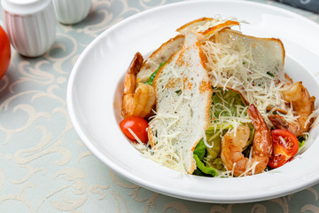salad caesar with shrimps on white plate