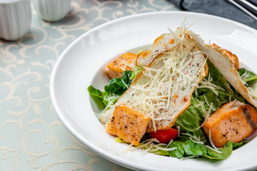 Caesar salad with salmon on plate
