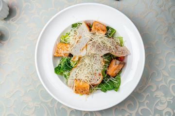 Caesar salad with salmon on plate
