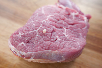Raw meat, beef steak on wooden background.