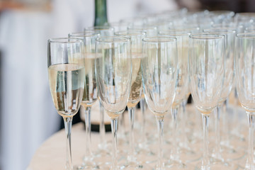 Champagne into glasses standing on the table