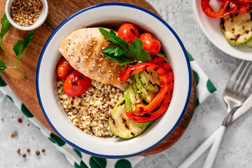 Healthy balanced foods. Bulgur and quinoa, chicken fillet and grilled vegetables in a plate, top view.