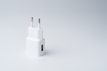 White USB power adapter for smartphone isolated on white background.