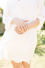 Obraz na płótnie Canvas Wedding ring and bracelet. The bride poses with a dressing gown.