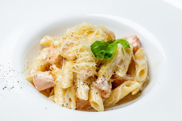 Penne with salmon on white plate