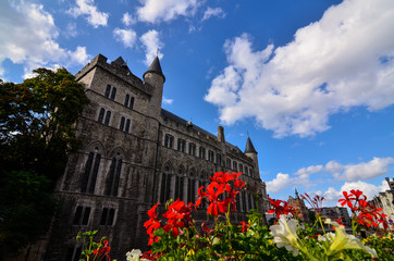 Ghent,Belgium,August 2019.Geraard de Duivelstraat Castle.The main facade overlooks the water: it is an example of the medieval buildings of the city.Blue sky with white clouds.Planters along the canal