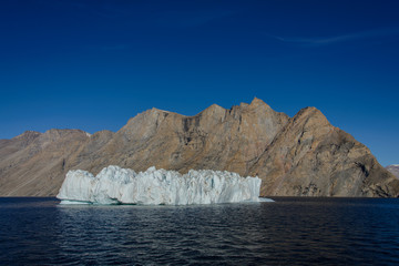 Obraz na płótnie Canvas Greenland landscape with beautiful coloured rocks and iceberg.