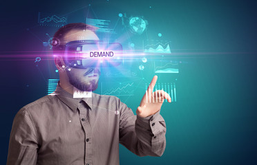 Businessman looking through Virtual Reality glasses with DEMAND inscription, new business concept