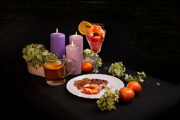Delicious food. Beautiful glass with lemon. Festive dinner. big candles. tangerines