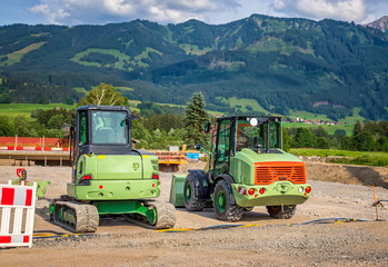 Stopped industry vehicles at the construction site,  on mountain background.