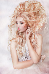 close up portrait of very beautiful girl with a magnificent hair and gold foil. white ball dress
