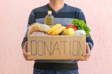 Man holds donation box with food.