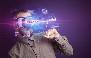 Businessman looking through Virtual Reality glasses with REGULATION inscription, new business concept