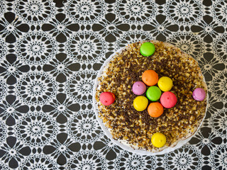 Home-made cake on a table covered with a beautiful tablecloth. The concept of making culinary products with family members.