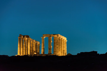 The famous ancient temple of Poseidon illuminated in Cape Sounio near Athens Greece on dusk