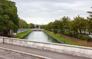 View  from the bridge to the Adige rive and embankments from two sides in Verona city, Italy.