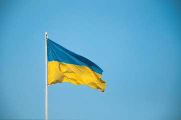 Ukraine flag Silk waving flag of Ukraine made transparent fabric  gold spear on background sunny blue sky real retro photo