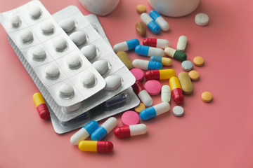 colorful pills spilling from container, top view 