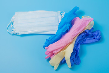 Multicolored medical protective surgical rubber gloves and mask on a blue background