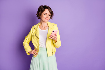 Portrait of positive charming addicted girl use cellphone read social network novelty subscribe repost wear good look yellow outfit isolated over purple color background