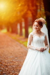 Fototapeta na wymiar Beautiful bride in fashion wedding dress on natural background.The stunning young bride is incredibly happy. Wedding day