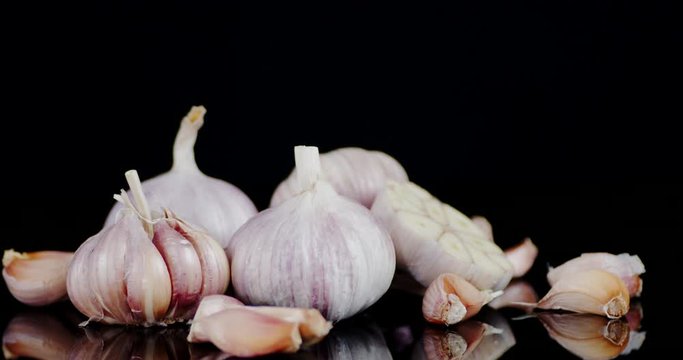Slices of fresh garlic slowly rotate.