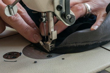 Needle and foot of sewing machine closeup as manufactoring background