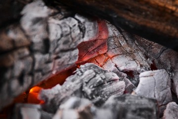 Glowing embers at the heart of a wood fire. Campfire, outdoors, rustic setting.