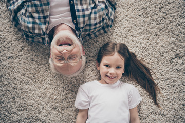 High angle top above photo of two people grandpa little granddaughter lying floor cozy fluffy...