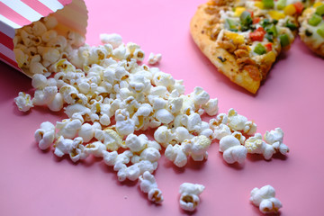 high angle view of popcorn and pizza on pink 