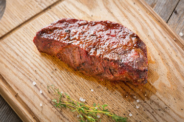 Hot Grilled Whole DenverHot Grilled Whole Denver Steak on Wooden Board with Herbs. Fresh Juicy Medium Rare Beef Grillsteak