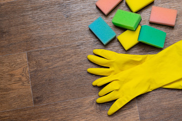 yellow rubber gloves and washcloths on wooden background