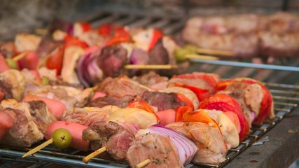 Pieces of meat and vegetable skewers on the grill at a typical argentinian barbecue.