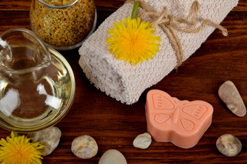 Fototapeta na wymiar baby soap in the shape of a butterfly, dandelion pollen, body oil next to the towel