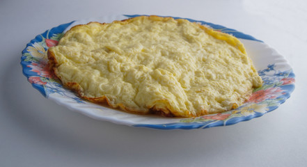 blue plate with omelette on a white background
