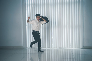 Young businessman dancing with his briefcase