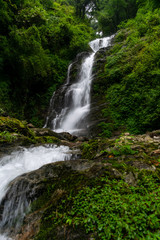 Fototapeta na wymiar a beautiful waterfall in the lap of mountain