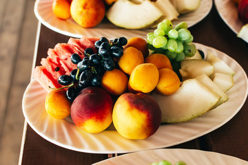 Plates with fruits on a wooden table closeup