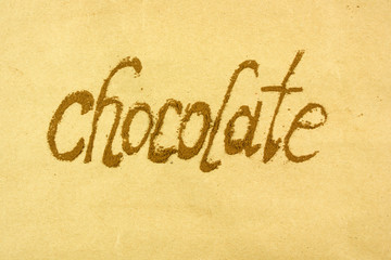 Fototapeta na wymiar the word chocolate is written with cocoa powder, chocolate mood, top view