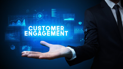 Hand of Businessman holding CUSTOMER ENGAGEMENT inscription, business success concept