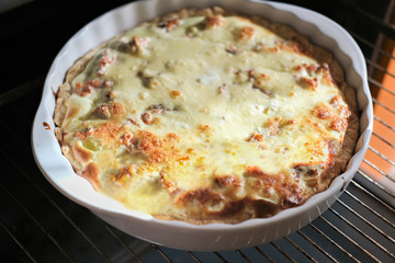 step by step visual instruction, how to prepare salmon quiche tart. Homemade quiche with salmon and cheese. step 6, ready baked pie in oven