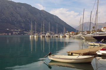 Port in Kotor city. Yachts and fishing boats on water on winter day. Montenegro, Adriatic Sea, Kotor Bay