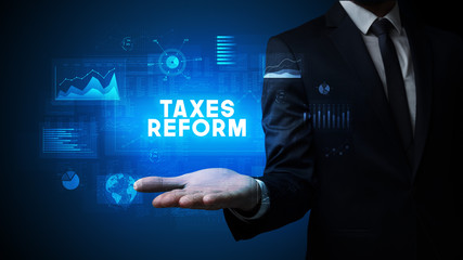 Hand of Businessman holding TAXES REFORM inscription, business success concept