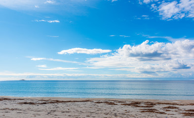 Blue sky with clouds over Maria Pia beach in Alghero
