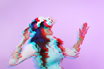Woman is using virtual reality headset. Image with glitch effect.
