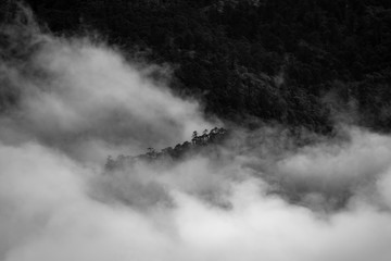 a beautiful mountain view with fog and clouds