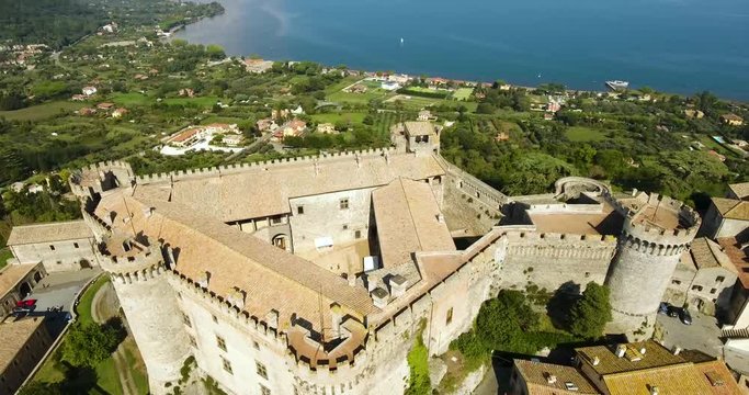 Aerial, tracking, drone shot tilting towards the Castello Orsini-Odescalchi castle, in Bracciano village, sunny day, in Lazio, Italy