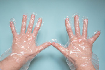 hands in disposable transparent gloves on a blue background