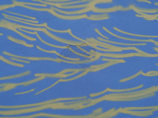 Fragment of a plastered blue wall with yellow lines.