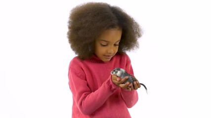 Little african girl is holding large decorative gray rodent with a wool tail at white background. Slow motion